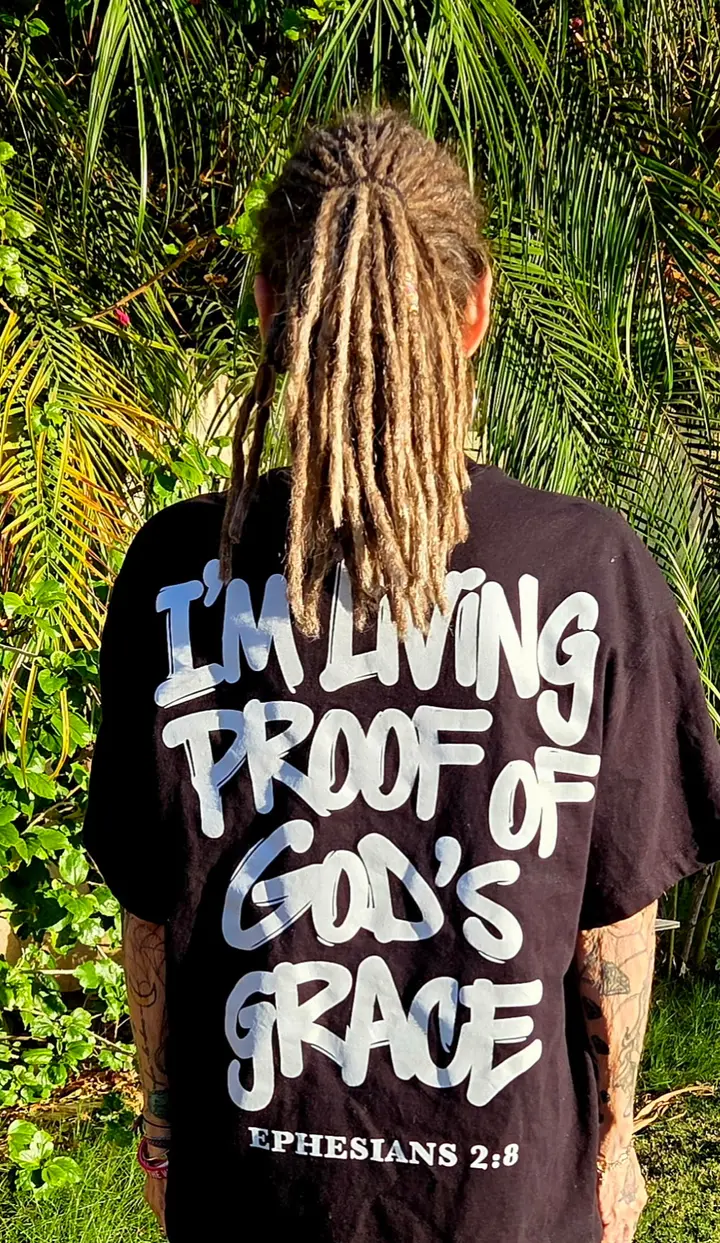 Lisa W. from behind, wearing the black Living Proof Tee with the full back print